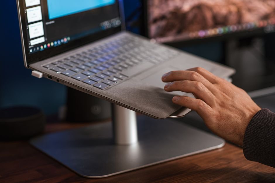 Laptop raised on a stand on a desk for airflow