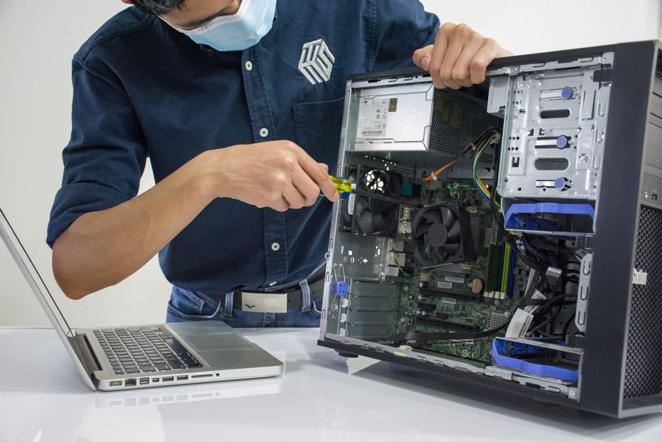 Technician repairing a desktop computer inside the case
