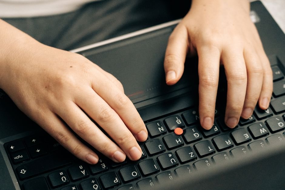Hands typing on a laptop keyboard to open an administrator command prompt