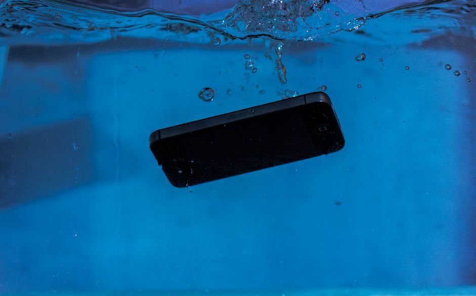 Hairdryer blowing hot air on a wet phone