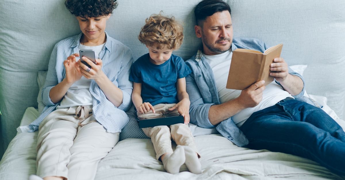 Family sitting together looking at tablet device