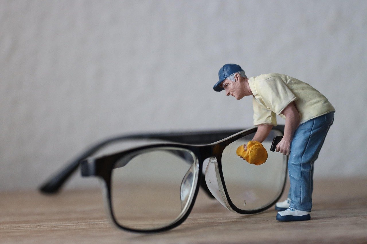 Person cleaning eyeglasses with solution